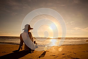 Young woman lying in straw hat in sunglasses on beach