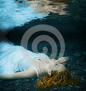 Young woman lying underwater.