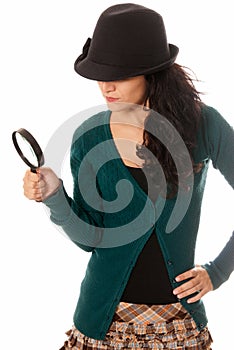 Young woman with magnifier glass and hat looking