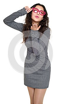 Young woman make flying kiss beautiful portrait, black and white checkered dress, pink sunglasses in heart shape, long curly