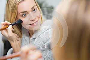 young woman make up yourself looking mirror