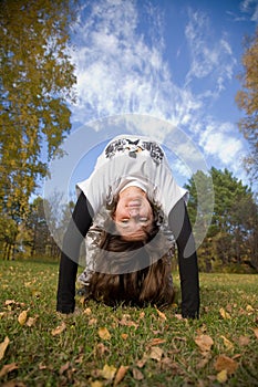 A young woman makes a handstand