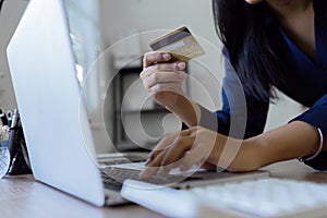 Young woman makes a purchase on the Internet on the laptop with credit card