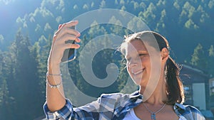 Young woman makes a video call with her cellphone and greets