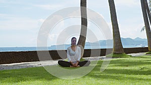 Young woman makes yoga practice, stretch, meditating, relaxing on the beach, beautiful background and nature sounds