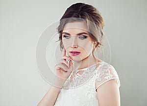 Young woman with makeup and bridal hairstyle. Pretty woman fiancee looking down, face closeup