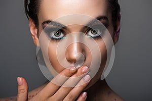 young woman with makeup gesturing oops sign