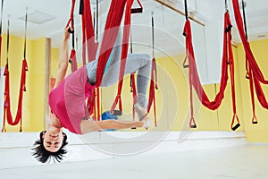 Young woman making antigravity yoga exercises