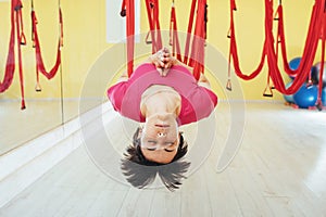 Young woman making antigravity yoga exercises
