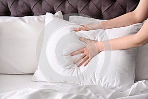 Young woman making bed