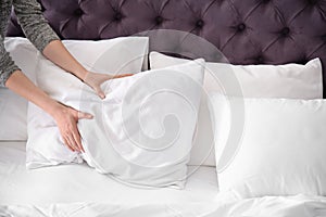 Young woman making bed