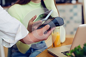 Young woman making card payment in cafeteria