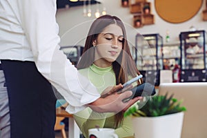 Young woman making card payment in cafeteria, summer bar