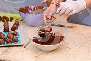 Young woman making chocolate candies.