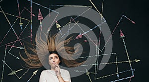 Young woman making decision with arrows written on school blackboard above head, brainstorming concept, girl finding solution in