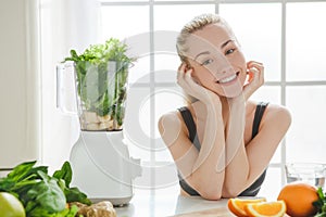Young woman making detox smoothie at home