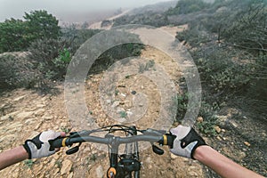 Young woman making downhill with her mountain bike