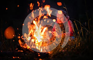 Young woman making fire while camping outdoors