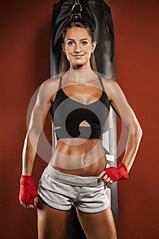 Young woman making a hard punch on a punching bag