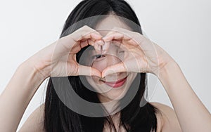 Young woman making heart shape by hands  with smiling face