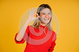 Young woman making ok gesture with hands.