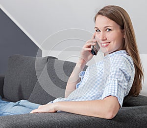 Young woman making phone call at home