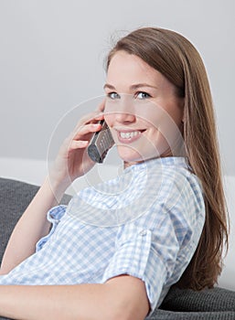 Young woman making phone call at home