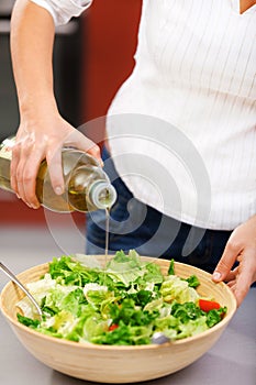 Young woman making salad