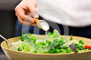 Young woman making salad