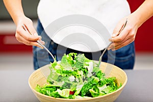 Young woman making salad