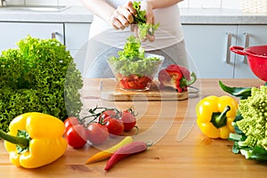 Young woman making salad in the kitchen