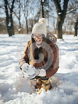 Young woman making snowball