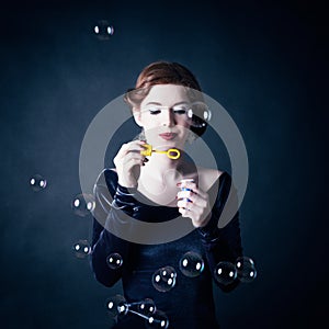 Young woman making soap bubbles