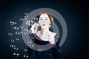 Young woman making soap bubbles