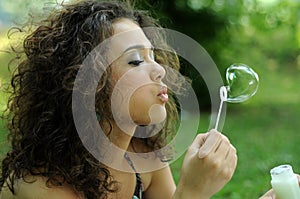 Young woman making soap bubbles