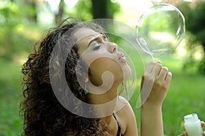 Young woman making soap bubbles