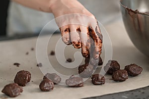 Young woman making truffles candy on kitchen