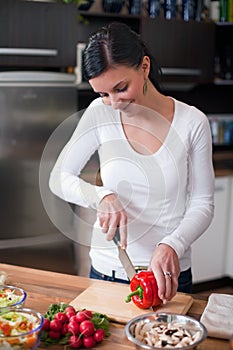 Young woman making vegetable salad