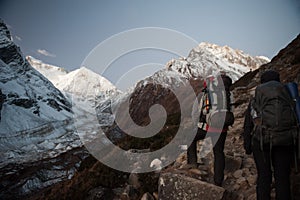 Young woman and man with backpacks walking to the pass on Manaslu circuit with view of Mount Manaslu range 8 156 meters. Trekkers