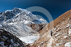 Young woman and man with backpacks walking to the pass on Manaslu circuit with view of Mount Manaslu range 8 156 meters. Trekkers