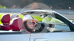 young woman and man in cabriolet, riding in convertible car in sunny day, auto trip in weekend