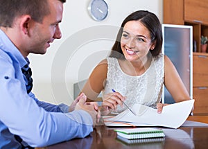 Young woman and man with financial documents in agency