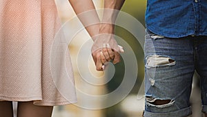 Young woman and man holding hands, tender relationship of sweet couple, love