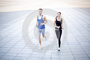 Young woman and man jogging in city copy space