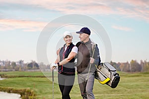 Young woman and man are playing golf