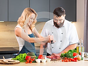 Young woman and man prepare food and host a cooking show. The bloggers stream from modern kitchen. Healthy food