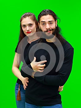 Young woman and man smiling cheerfully stand on the green chroma key background. There is a blank space for advertising content on