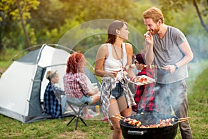 Young woman and man tasting roasted barbecue