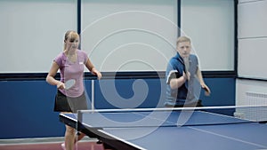 Young woman and man together playing in a table tennis