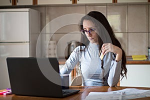 Young woman managing bills online with credit card